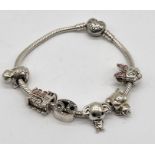 A silver Pandora bracelet with a number of charms including Minnie Mouse, Dobby, Hogwarts Express,