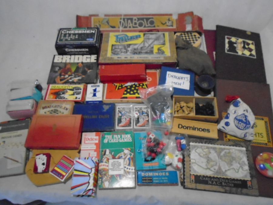 A collection of vintage games including chess, draughts, playing cards, bag of marbles, diabolo,