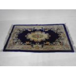 A Chinese blue ground rug - Overall size 210cm x 122cm