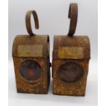 Two weathered vintage road works lamps.