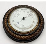 A circular barometer with Reaumur thermometer in wooden rope-twist surround