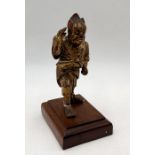 An Oriental carved figure of an Oni on wooden plinth (A/F) - height 18cm.