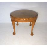 A small circular coffee table, with carved detailing.