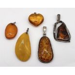 Five Baltic amber pendants-some set in 925 silver including a large butterscotch pendant (5.5cm