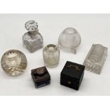 A collection of antique inkwells and match strikers including a leather cased example