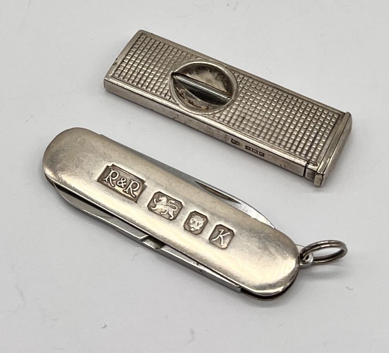 A hallmarked silver cigar cutter along with a silver cased penknife