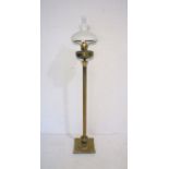 A turn of the century brass floorstanding oil lamp on Corinthian column base, with glass shades.