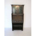 An oak Arts and Crafts bureau bookcase, with copper hinges and stained glass panels, some pieces
