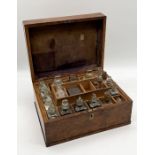 A 19th century oak cased travelling apothecary box with 24 glass bottles, many with labels, velvet