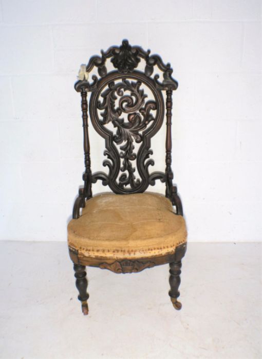 A Victorian nursing chair, with carved Black Forest style decoration to back - in need of