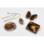 An amber butterfly brooch set in 925 silver along with a silver and amber acorn pendant and two