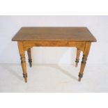 A pine centre table raised on turned legs, length 102cm, width 49cm, height 74cm.