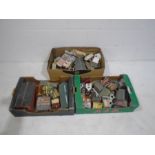 Three boxes of OO gauge model railway buildings including churches, shops, pub, railway station,