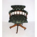 A green leather button-back Captain's chair.