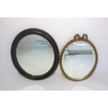 A gilt framed oval wall mirror, along with an Edwardian oval wall mirror.