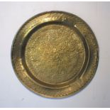 A large wall hanging Eastern brass tray with embossed pattern.