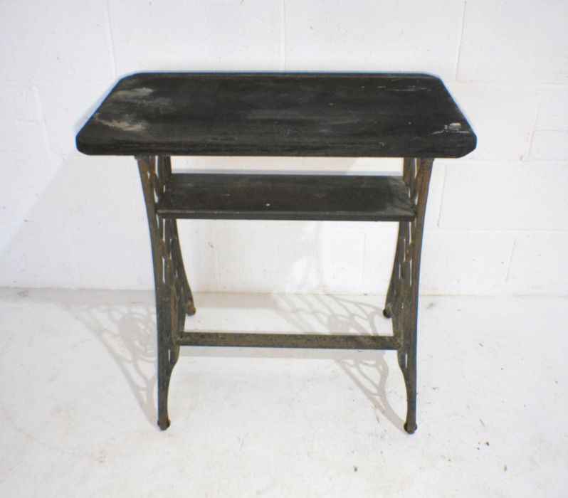 A garden table converted from a Singer sewing machine base with wooden top.