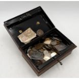 A collection of various UK and worldwide coinage in vintage cash tin