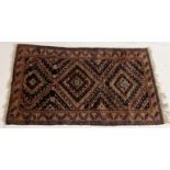 An Eastern red ground rug (some sun damage) 186cm x 107cm