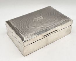 A hallmarked silver cigarette box with Greek key design to rim