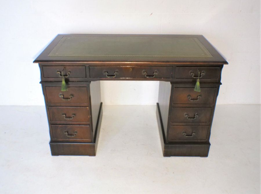 A reproduction mahogany kneehole desk, with green leather inset top, length 121cm, depth 61cm,