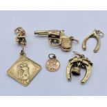Six 9ct gold charms including a revolver, pixie, lucky horseshoe etc. total weight 7.3g
