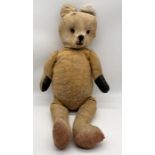 A large antique straw filled teddy bear - height 80cm