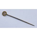 An unmarked rose gold tie pin/stick pin set with 7 diamonds