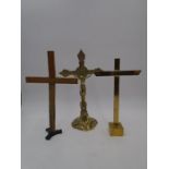 A vintage brass crucifix along with two crosses on stands, height of crucifix 33.5cm