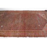 A large red ground rug.415cm x 207cm. A/F