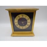 A contemporary brass mantle clock by Looping, with faux tortoiseshell background, quartz movement