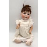 A Johann Daniel Kestner bisque head character doll with open mouth and bent limbed composition body,