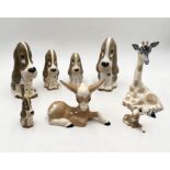 A collection of Szeiler porcelain animals including five dogs, two donkeys and a giraffe