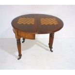 A Victorian mahogany fold-over games table on fluted legs, diameter 95cm.