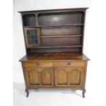 An Arts & Crafts oak dresser with stained glass panel to cupboard