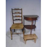 A vintage demi-lune table plus a ladder-back chair and a stool.,