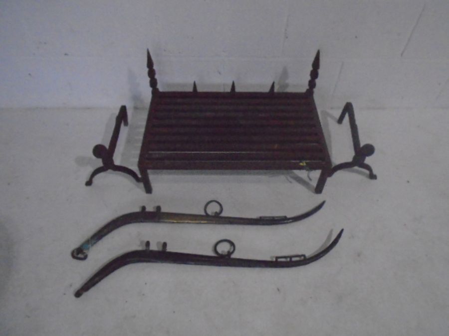 A cast iron fire grate, along with a pair of fire dogs and two brass horse hames