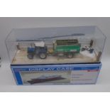 A cased diorama of a Ford Powerstar SL 6640 tractor with Keenan Klassik 140 in Master Tools