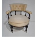 A Victorian tub chair with button back upholstery on fluted supports.