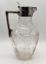 A cut glass claret jug with hallmarked silver lid and handle by Walker & Hall