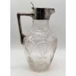 A cut glass claret jug with hallmarked silver lid and handle by Walker & Hall
