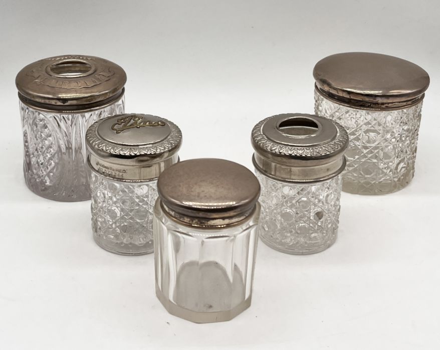 Three silver topped dressing table pots along with two others