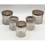 Three silver topped dressing table pots along with two others