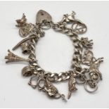 A hallmarked silver charm bracelet with a collection of various charms, total weight 63.5g