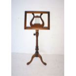 A reproduction mahogany music stand on tripod base.