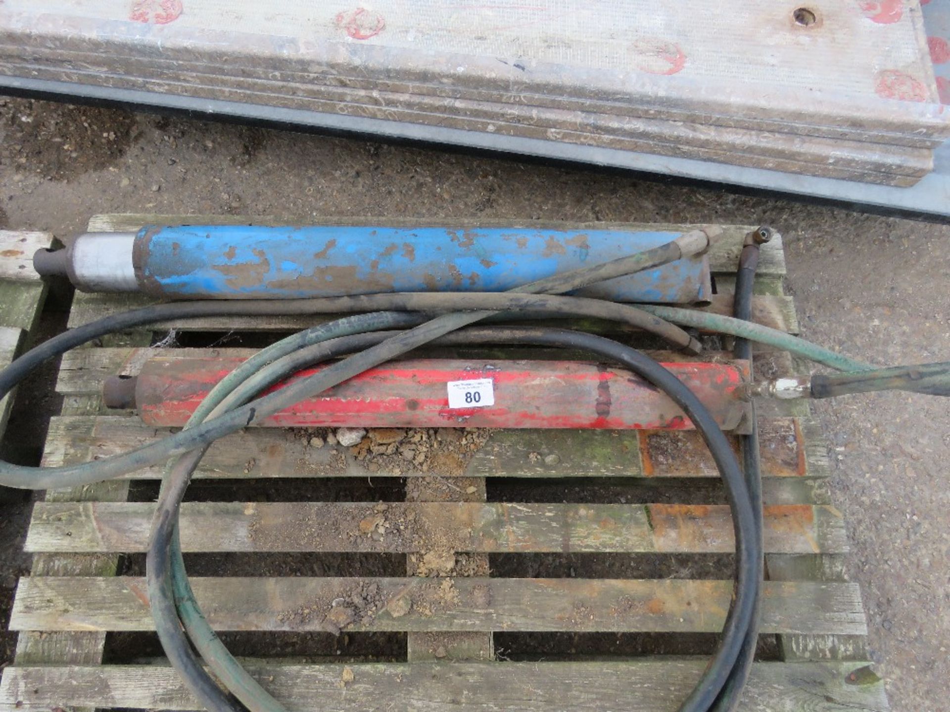 2 X HEAVY DUTY HYDRAULIC RAMS WITH HOSES.