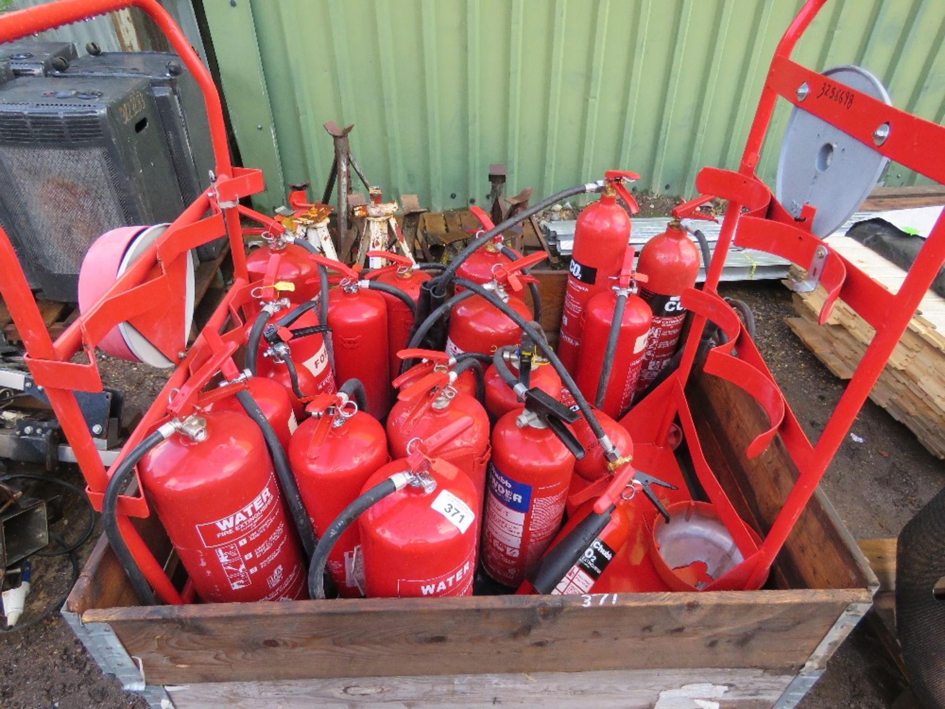 STILLAGE OF ASSORTED FIRE EXTINGUISHERS AND STANDS.