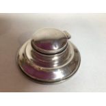 A silver inkwell with liner