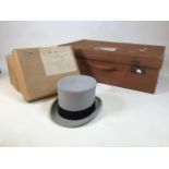 A boxed James Lock top hat (some moth damage) together with a canvas suit case with a Swedish