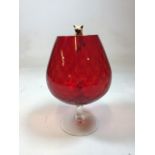 A mid century red glass goblet with cat and mouse figures. Repair to cat and damage to one ear.